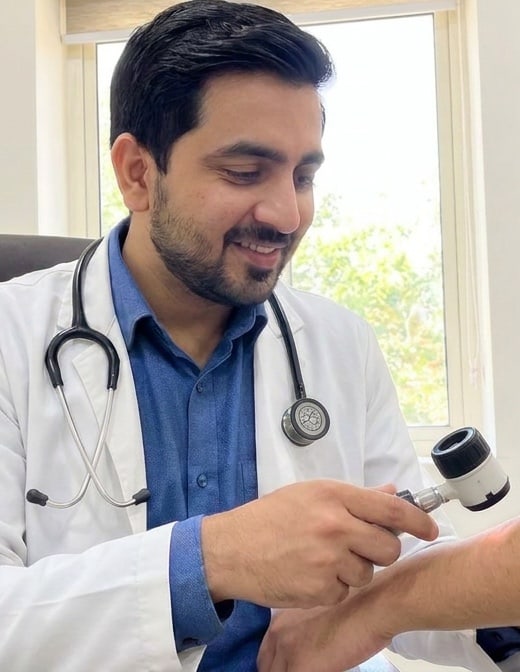 Dr. Raghvendra Pratap Singh examining a patient's skin with a dermatoscope at MySkin Clinic, Orai